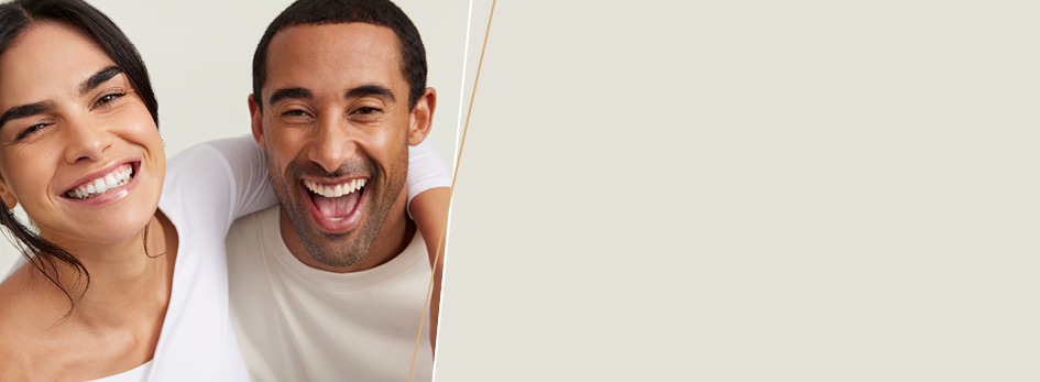 Eine Frau umarmt einen Mann – beide lächeln fröhlich in die Kamera