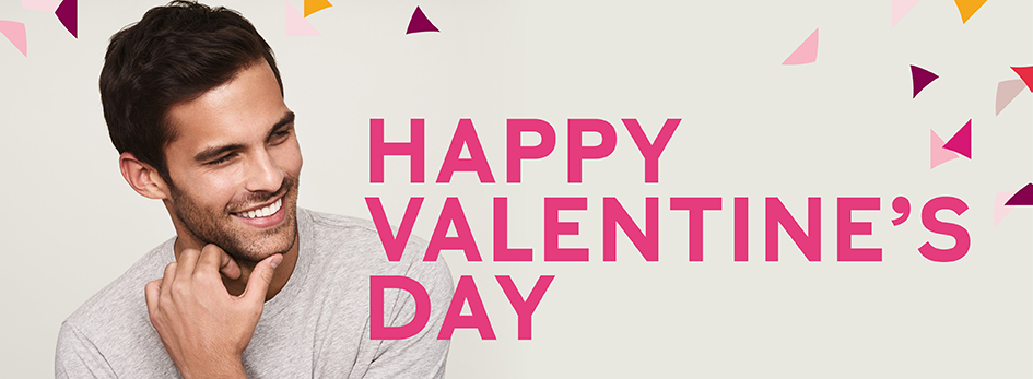 Ein lächelnder Mann blickt zur Seite – daneben in pinken Buchstaben der Schriftzug „HAPPY VALENTINE’S DAY“.
