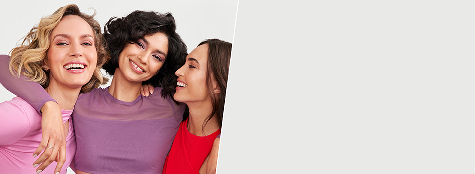 Drei Frauen umarmen sich und lächeln