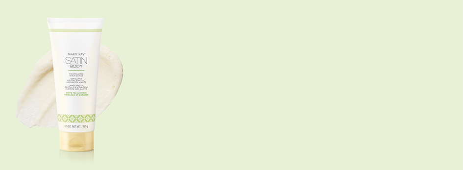Das Satin Body® Revitalizing Shea Scrub White Tea & Citrus liegt zusammen mit einem weißen, geschmeidigen Produktkleks auf einem lindgrünen Hintergrund.