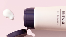 Geöffneter TimeWise® 4-In-1 Cleanser neben einem zentimetergroßen Klecks des Produkts auf einem hellrosa Hintergrund