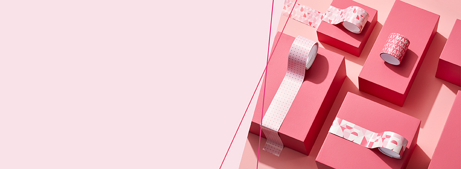 Einige Geschenk, die in rosa Geschenkpapier eingepackt sind, werden mit Mary Kay Bändern verziert